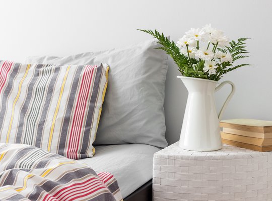 White-flowers-and-books-on-a-bedside-table-